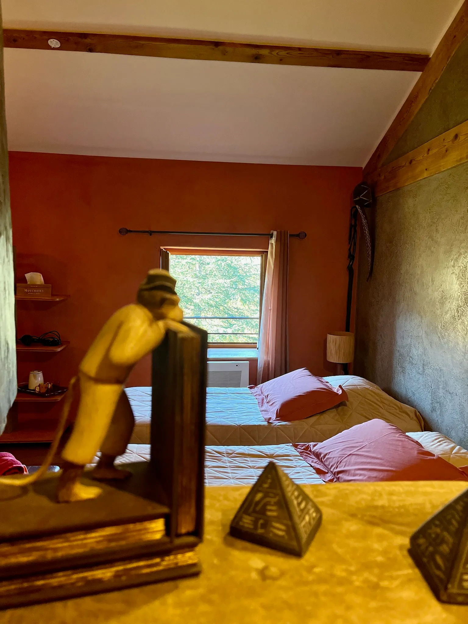 Chambre africaine - Décoration de la chambre africaine avec lit en arrière-plan et vue sur le jardin