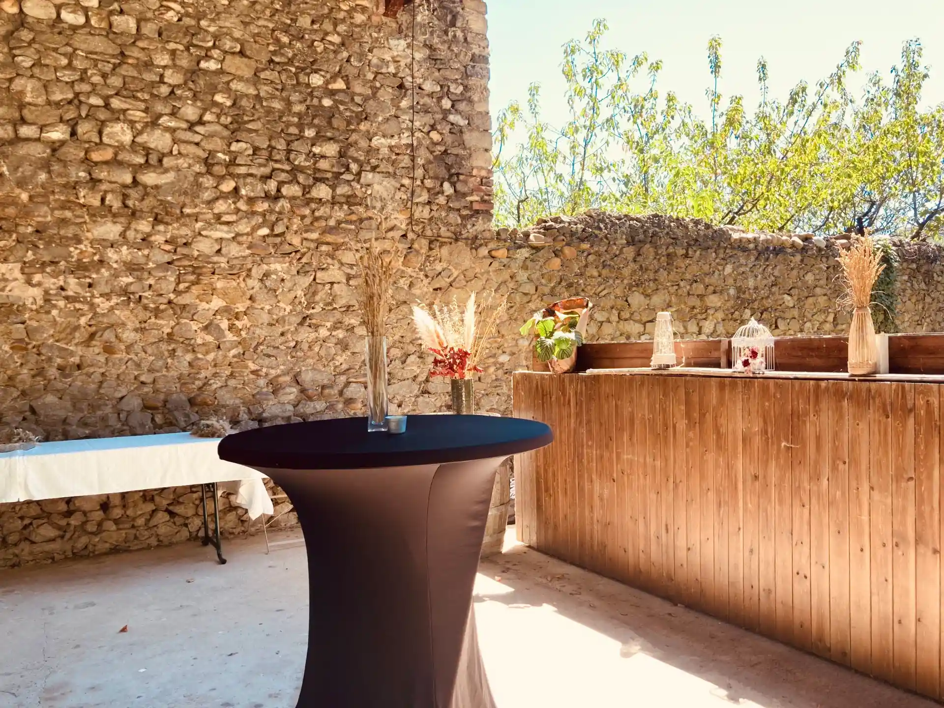Abri couvert décoré pour un mariage avec bouquets floraux baignés de soleil