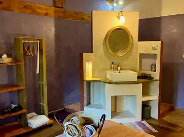 Chambre toscane - Espace de rangement pour les vêtements avec vasque simple et douche en tadelakt en arrière-plan