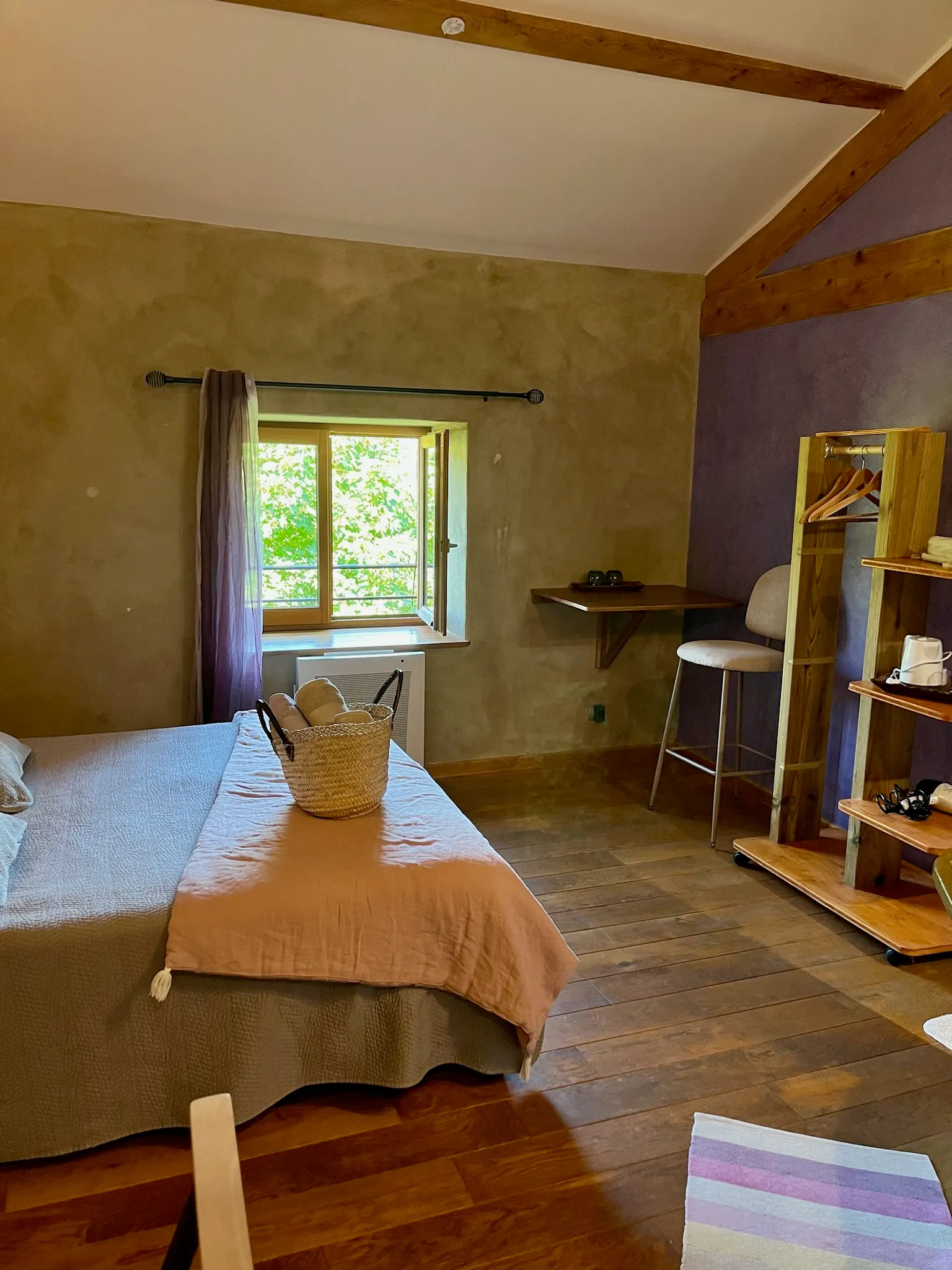 Chambre toscane - Chambre baignée de lumière avec vue sur le jardin, serviettes disposées sur le lit et espace de rangement pour les vêtements